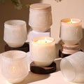 Six creamy-white floral glass candle jars